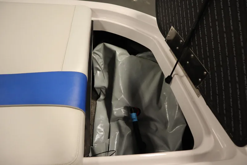 Slide: The Image of 2011 Nautique 210 SUPER AIR storage compartment with blue and white seat cushion. - 49