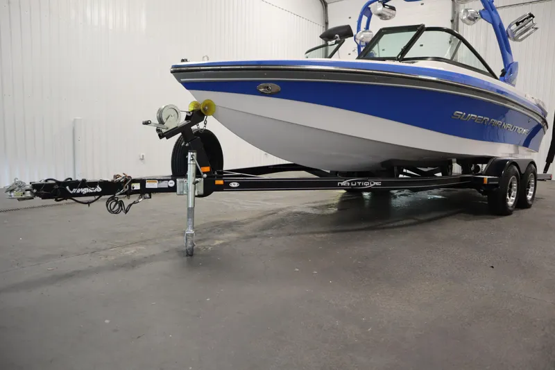 Slide: The Image of 2011 Nautique 210 SUPER AIR boat on trailer in indoor setting. - 55