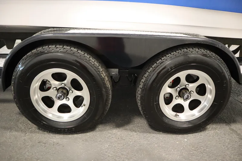 Slide: The Image of Trailer wheels of a 2011 Nautique 210 SUPER AIR boat, featuring dual axles. - 57
