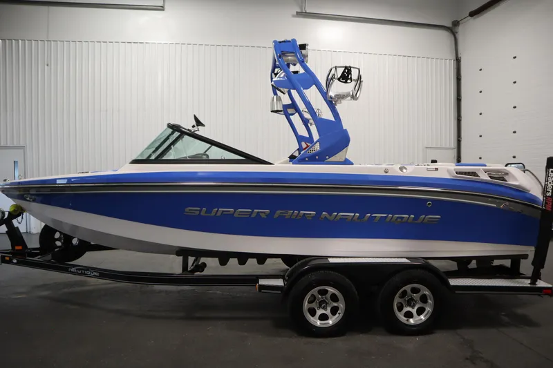 Slide: The Image of 2011 Nautique 210 SUPER AIR boat in blue and white on a trailer. - 8