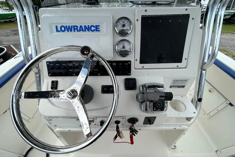 Slide: The Image of 2007 Triton 2486cc boat dashboard with steering wheel, gauges, and Lowrance system. - 12