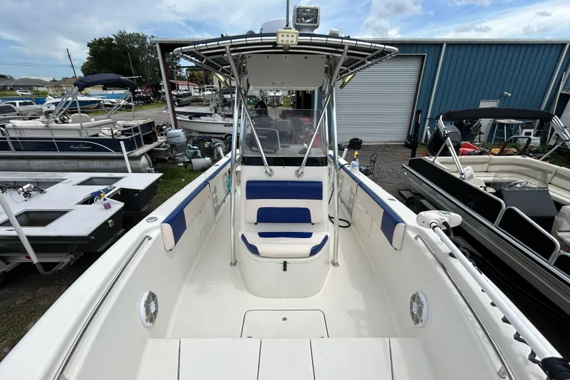 Slide: The Image of 2007 Triton 2486cc boat with blue accents, docked among other boats. - 18