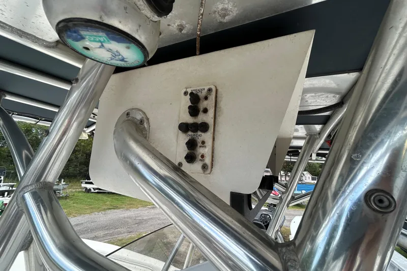 Slide: The Image of 2007 Triton 2486cc boat control panel with switches and metal framework. - 19