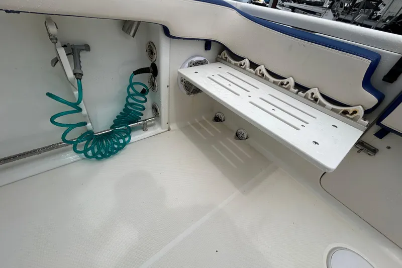 Slide: The Image of 2007 Triton 2486cc boat interior with rod holders and coiled hose. - 20