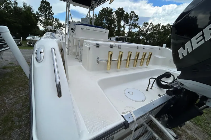 Slide: The Image of 2007 Triton 2486cc boat with Mercury engine, featuring rod holders and spacious deck. - 5