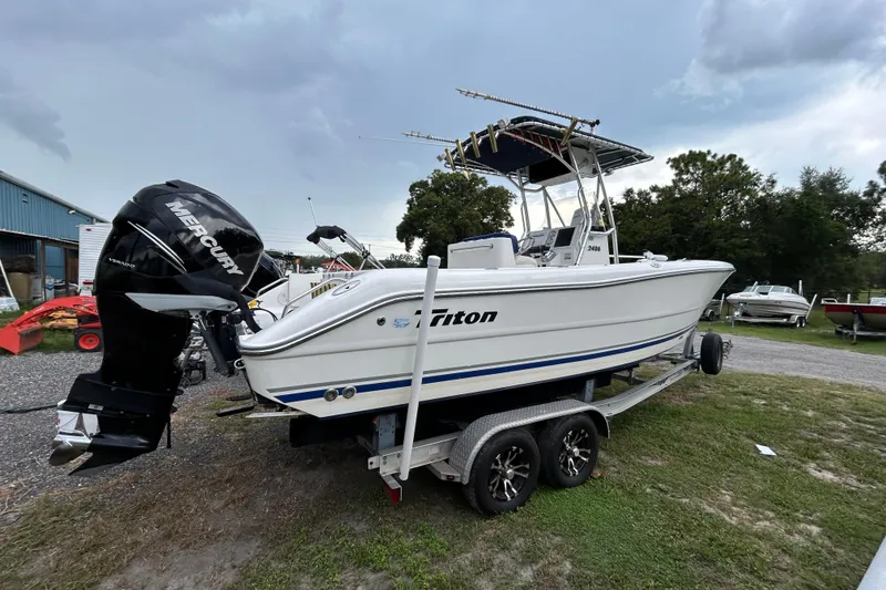 Slide: The Image of 2007 Triton 2486cc boat on trailer with Mercury outboard motor, parked outdoors. - 7