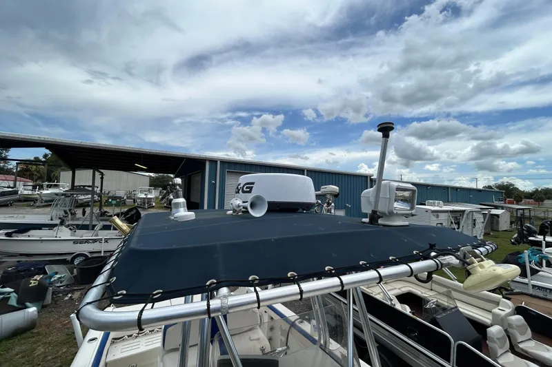 Slide: The Image of 2007 Triton 2486cc boat with radar and equipment, docked under cloudy sky. - 9