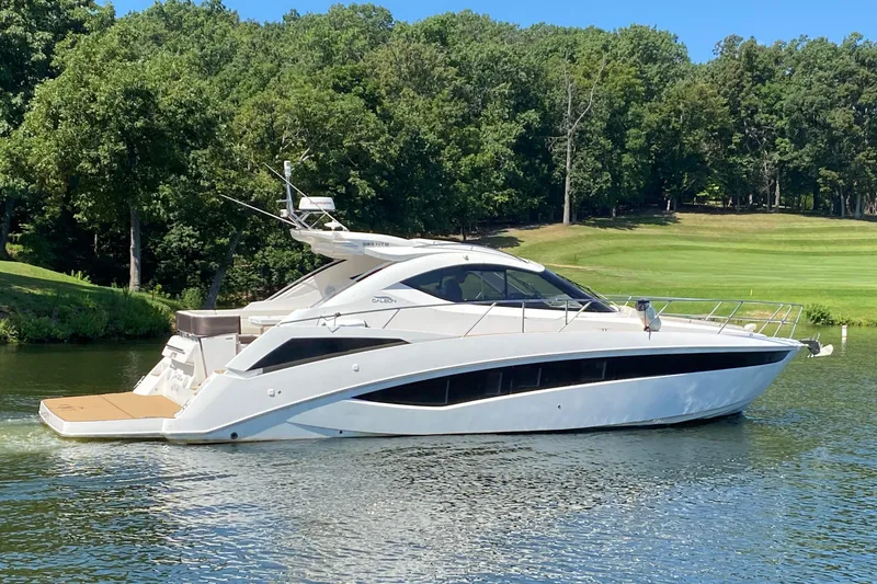 Slide: The Image of 2018 Galeon 385 HTS yacht cruising on a serene lake with lush greenery. - 3