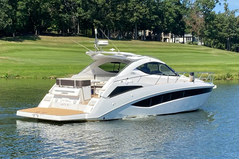 Slide: The Image of 2018 Galeon 385 HTS yacht cruising on a serene lake with lush greenery. - 5