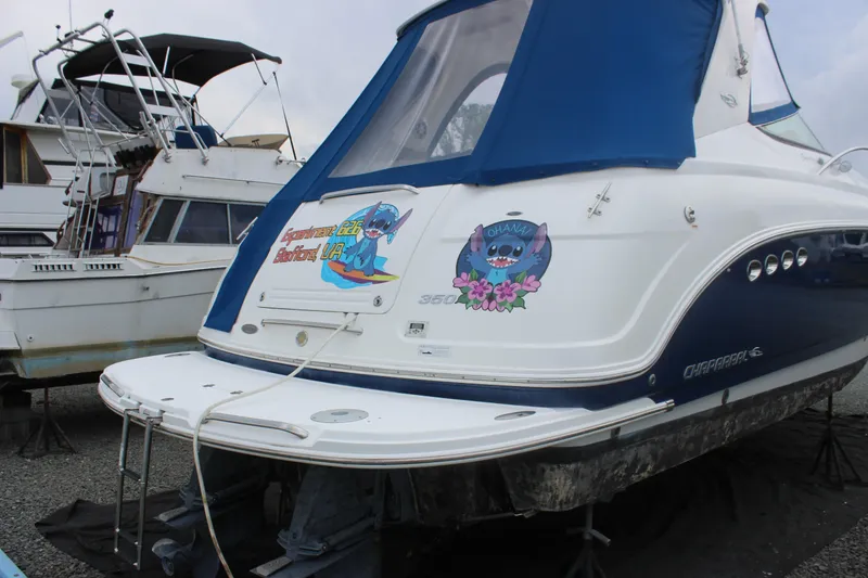 Slide: The Image of 2008 Chaparral Signature 350 boat with blue cover and colorful decals in a marina. - 12