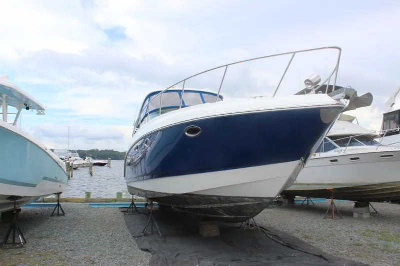 Slide: The Image of 2008 Chaparral Signature 350 boat on dry dock, blue and white hull, marina background. - 2