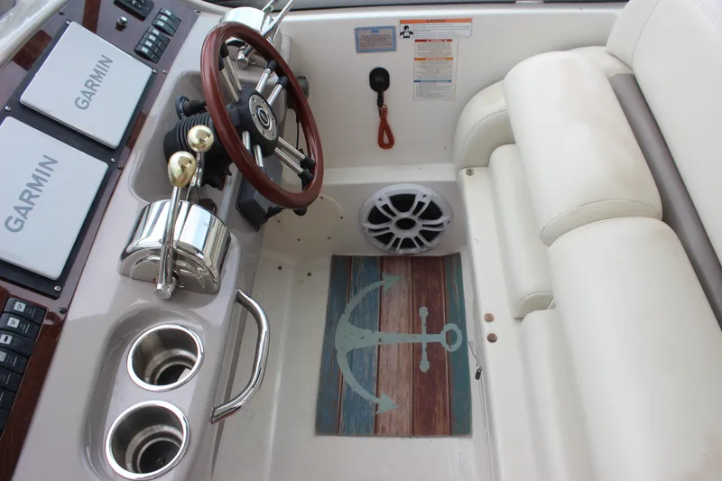 Slide: The Image of 2008 Chaparral Signature 350 helm with Garmin displays, wooden steering wheel, and anchor-themed mat. - 22