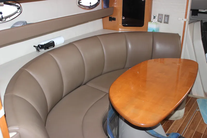 Slide: The Image of 2008 Chaparral Signature 350 interior with curved leather seating and wooden table. - 39