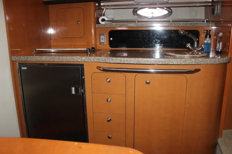 Slide: The Image of 2008 Chaparral Signature 350 yacht interior kitchen with wood cabinetry and stainless steel sink. - 52