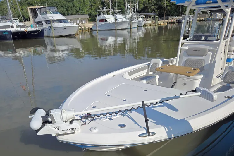 Slide: The Image of 2022 Caymas 28 HB boat on forklift at marina, blue hull, clear sky. - 10