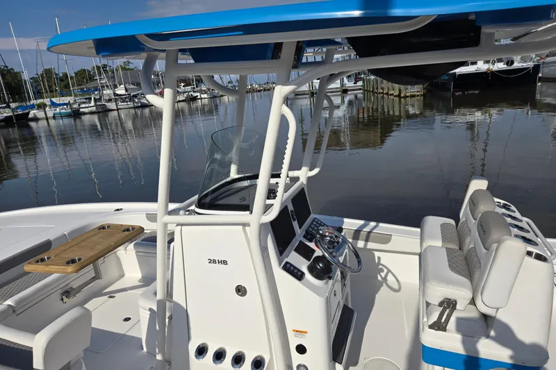 Slide: The Image of 2022 Caymas 28 HB boat docked, featuring a spacious deck and seating area. - 12