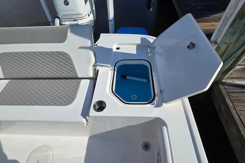Slide: The Image of 2022 Caymas 28 HB boat with cushioned seating and motor at a marina dock. - 17
