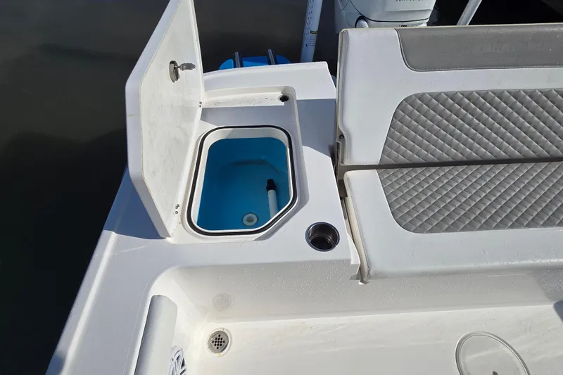 Slide: The Image of 2022 Caymas 28 HB boat interior with open storage compartment and cushioned seating. - 18