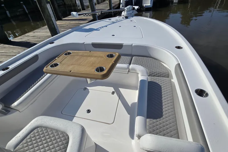 Slide: The Image of 2022 Caymas 28 HB boat interior with open storage compartment and cushioned seating. - 19