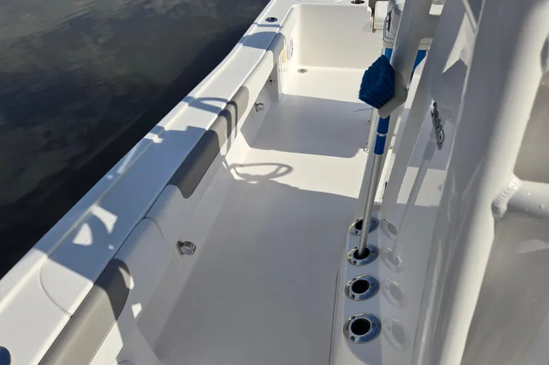 Slide: The Image of 2022 Caymas 28 HB boat interior with rod holders and clean deck by dock. - 25