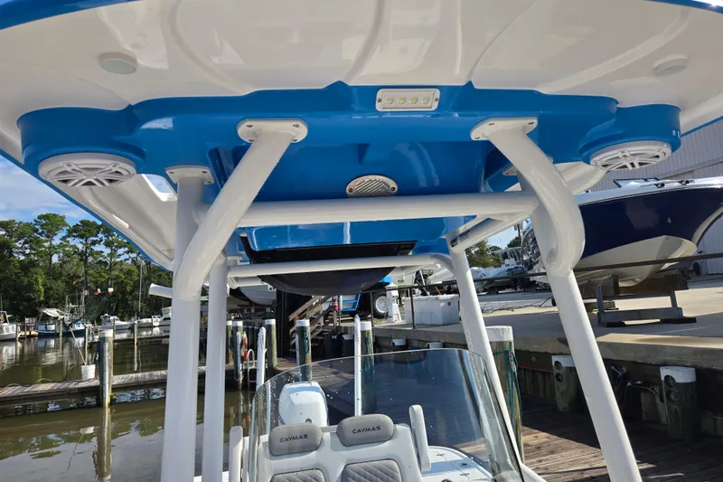 Slide: The Image of 2022 Caymas 28 HB boat with blue and white T-top, docked at marina. - 27