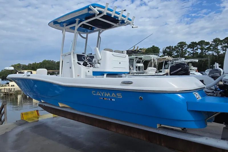 Slide: The Image of 2022 Caymas 28 HB boat lifted by forklift at marina, clear sky background. - 4