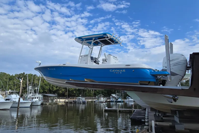 Slide: The Image of 2022 Caymas 28 HB boat in vibrant blue, docked at a marina. - 5