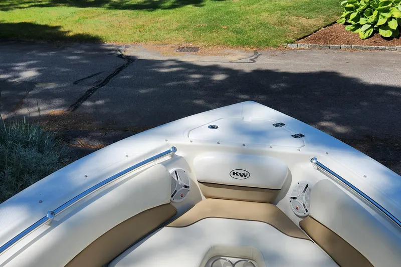 Slide: The Image of Bow of 2012 Key West 211 DC boat with seating and speakers, parked on a driveway. - 11