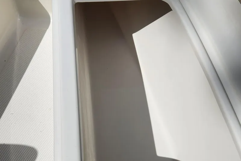 Slide: The Image of Storage compartment of a 2012 Key West 211 DC boat, featuring clean white interior. - 14