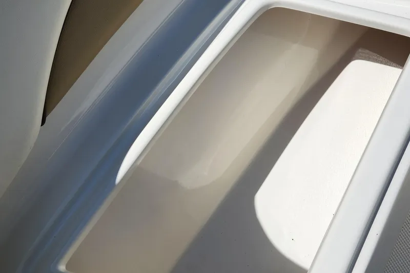 Slide: The Image of Storage compartment of a 2012 Key West 211 DC boat, featuring a clean, white interior. - 15