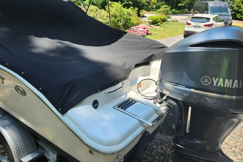 Slide: The Image of 2012 Key West 211 DC boat with Yamaha outboard motor, covered and parked outdoors. - 4