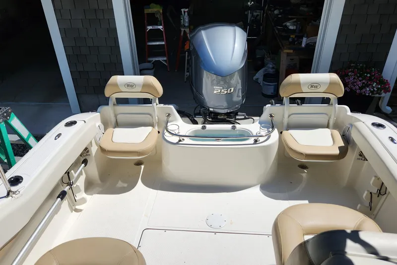 Slide: The Image of 2012 Key West 211 DC boat interior with Yamaha 250 engine, beige seating, and fishing rod holders. - 9