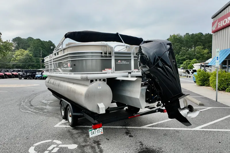 Slide: The Image of 2023 Sun Tracker Party Barge 22 DLX pontoon boat on trailer in parking lot. - 3