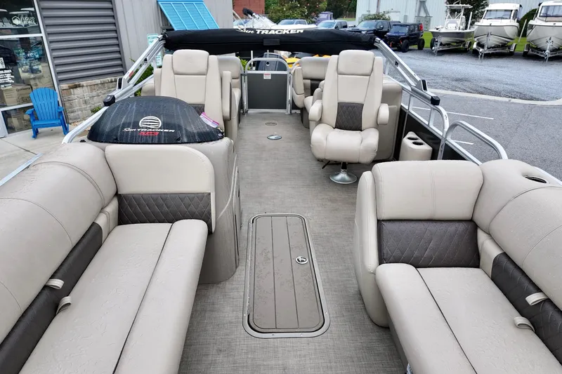 Slide: The Image of 2023 Sun Tracker Party Barge 22 DLX interior with beige seating and spacious layout. - 5