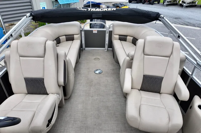 Slide: The Image of 2023 Sun Tracker Party Barge 22 DLX interior with beige seating and spacious layout. - 6