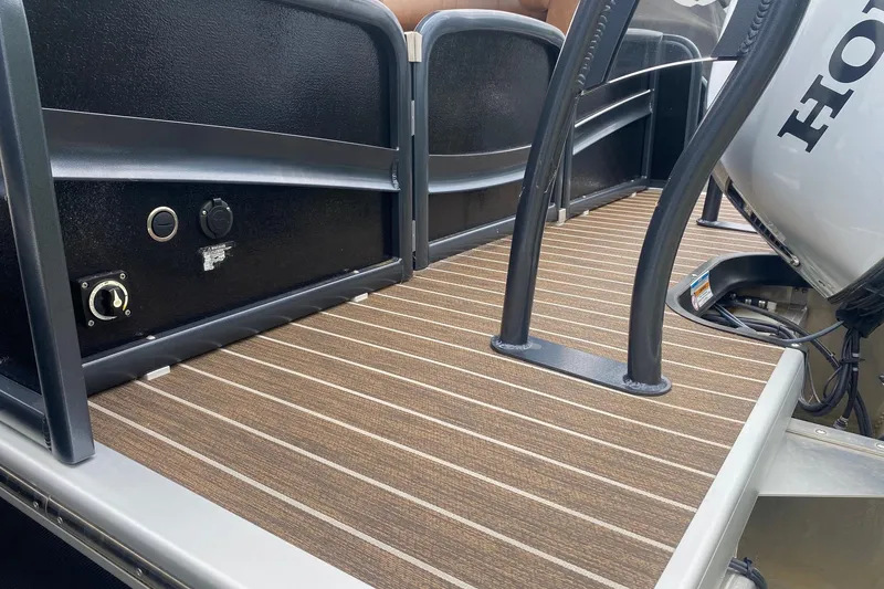 Slide: The Image of 2022 Premier 270 Intrigue RF boat deck with Honda engine, featuring brown striped flooring. - 10
