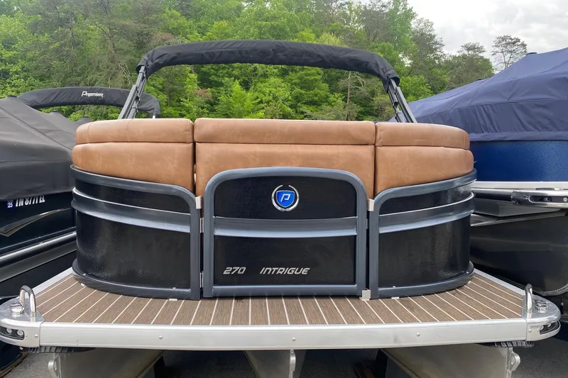 Slide: The Image of 2022 Premier 270 Intrigue RF pontoon boat with tan seating and sleek black exterior. - 11