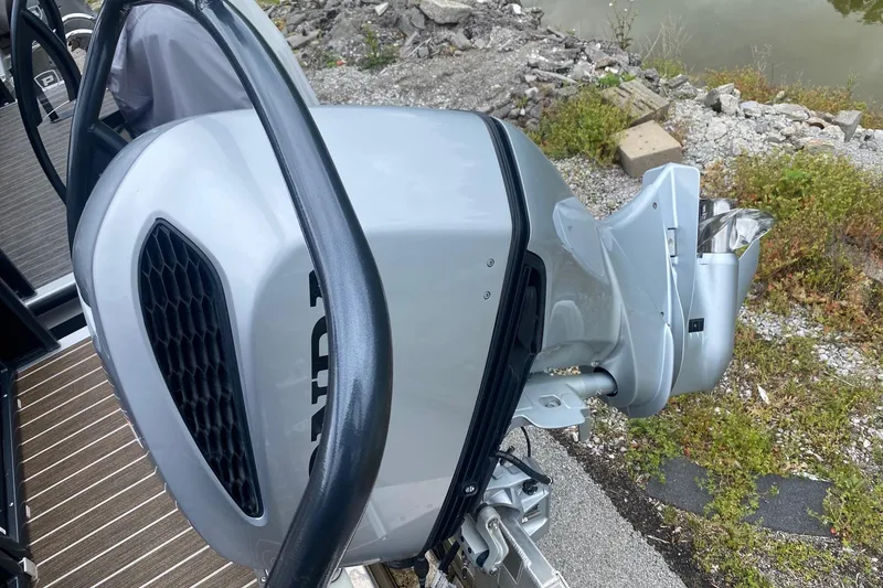 Slide: The Image of 2022 Premier 270 Intrigue RF boat engine detail by a rocky shoreline. - 12