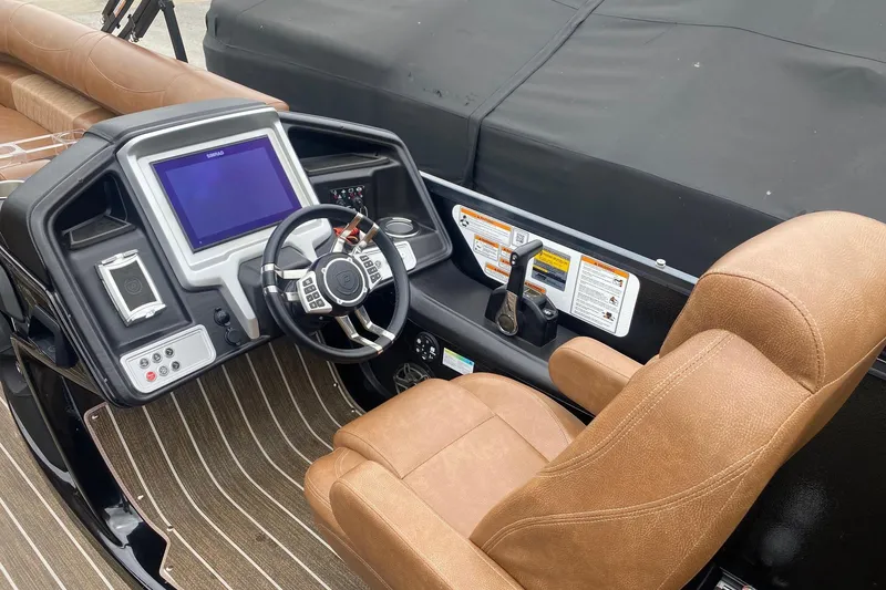 Slide: The Image of 2022 Premier 270 Intrigue RF boat cockpit with modern controls and brown seating. - 7