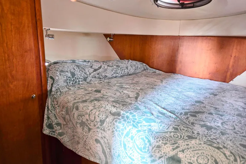 Slide: The Image of Cozy bedroom in 2003 Silverton 392 Motor Yacht with patterned bedding and wood paneling. - 12