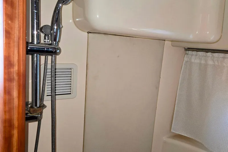 Slide: The Image of 2003 Silverton 392 Motor Yacht bathroom with showerhead and curtain. - 16