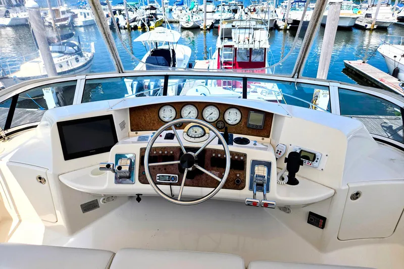 Slide: The Image of Helm of 2003 Silverton 392 Motor Yacht with marina view, featuring navigation instruments and controls. - 19