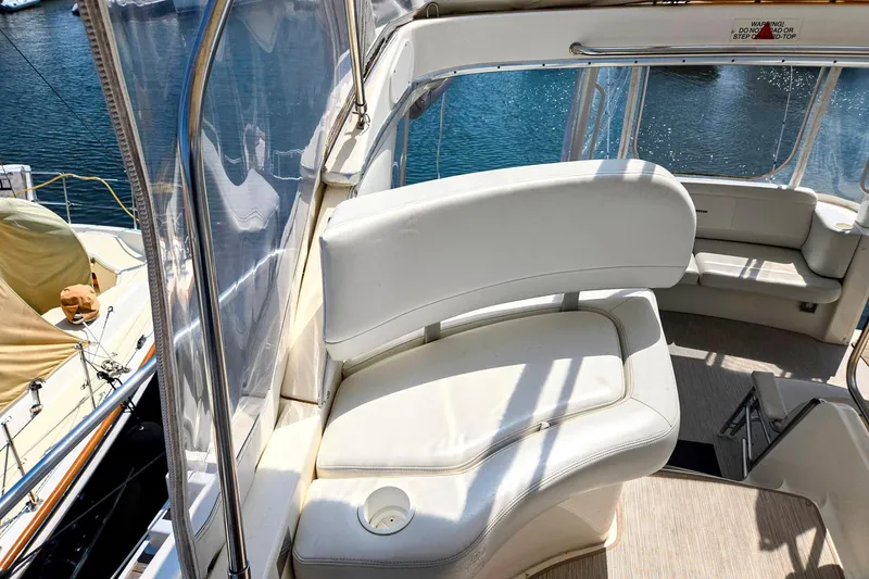 Slide: The Image of 2003 Silverton 392 Motor Yacht interior with white seating and clear water view. - 26