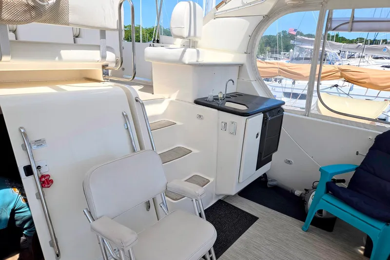 Slide: The Image of 2003 Silverton 392 Motor Yacht interior with seating, kitchenette, and marina view. - 30