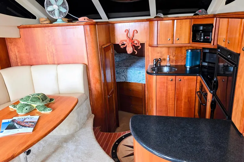 Slide: The Image of Luxurious 2003 Silverton 392 Motor Yacht interior with kitchen and cozy seating area. - 7