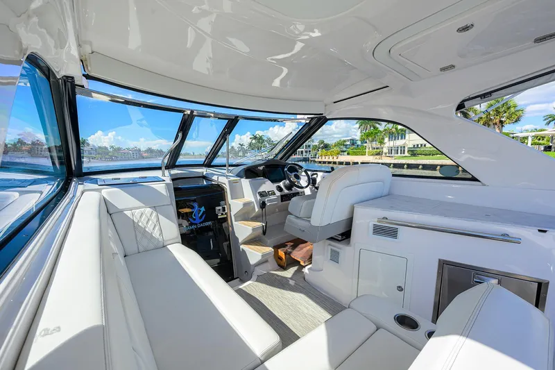 Slide: The Image of Luxurious interior of 2020 Regal 35 Sport Coupe yacht with white seating and panoramic windows. - 10