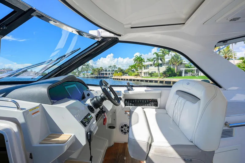 Slide: The Image of 2020 Regal 35 Sport Coupe cockpit with luxurious seating and waterfront view. - 13