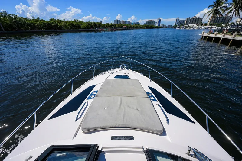 Slide: The Image of 2020 Regal 35 Sport Coupe cruising on a sunny waterway with city skyline. - 30