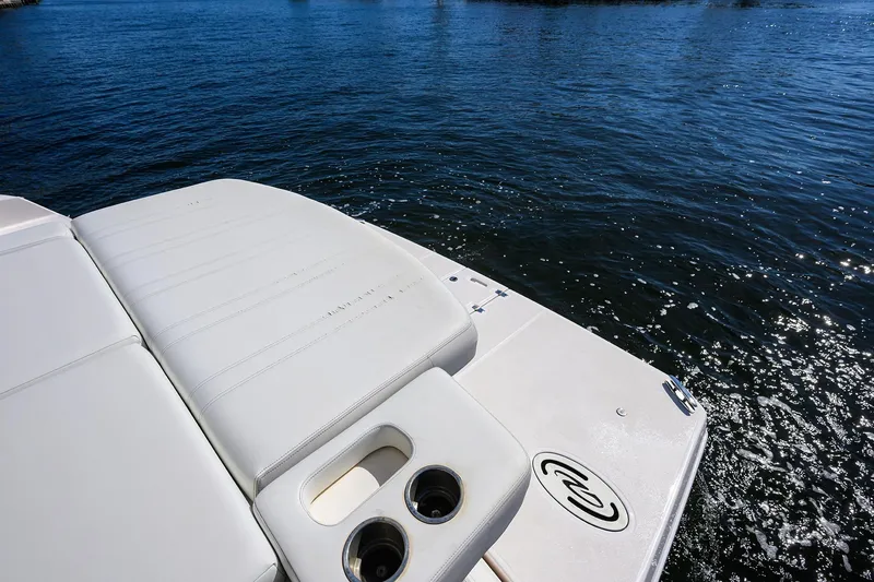 Slide: The Image of 2020 Regal 35 Sport Coupe boat deck with cup holders on calm water. - 35