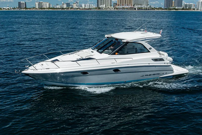 Slide: The Image of 2020 Regal 35 Sport Coupe cruising on open water near city skyline. - 40